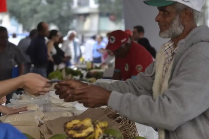 Agricultor familiar assinando documentos de renegociação de dívidas.
