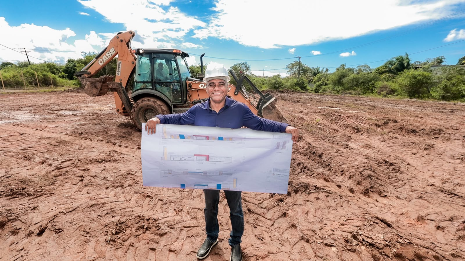 Registro do prefeito Del no início da obra, com o terreno e a equipe responsável pela construção ao fundo.