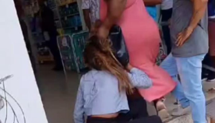 Duas mulheres sendo agredidas após serem flagradas furtando em farmácia de Simões Filho.