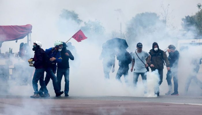 Manifestantes do movimento "Bloqueie Tudo" segurando cartazes e bandeiras em protesto